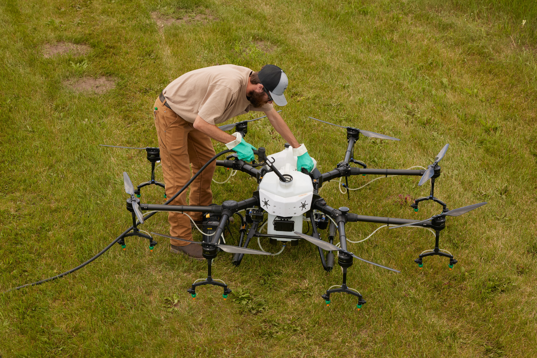 Applicator filling drone tank in a field